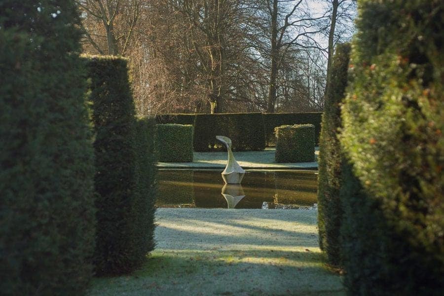 The Pond Garden: Formal pool surrounded by hedge of Taxus Baccata. Sculpture of White