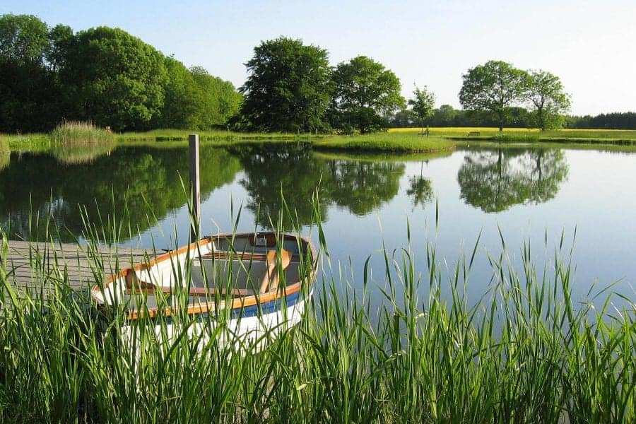 Farleigh House lake view with boat in foreground