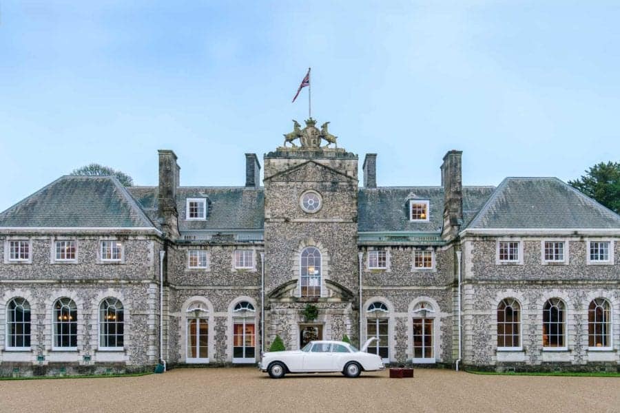 The front facade of Farleigh House: UK corporate venue retreat, with a Bentley parked outside